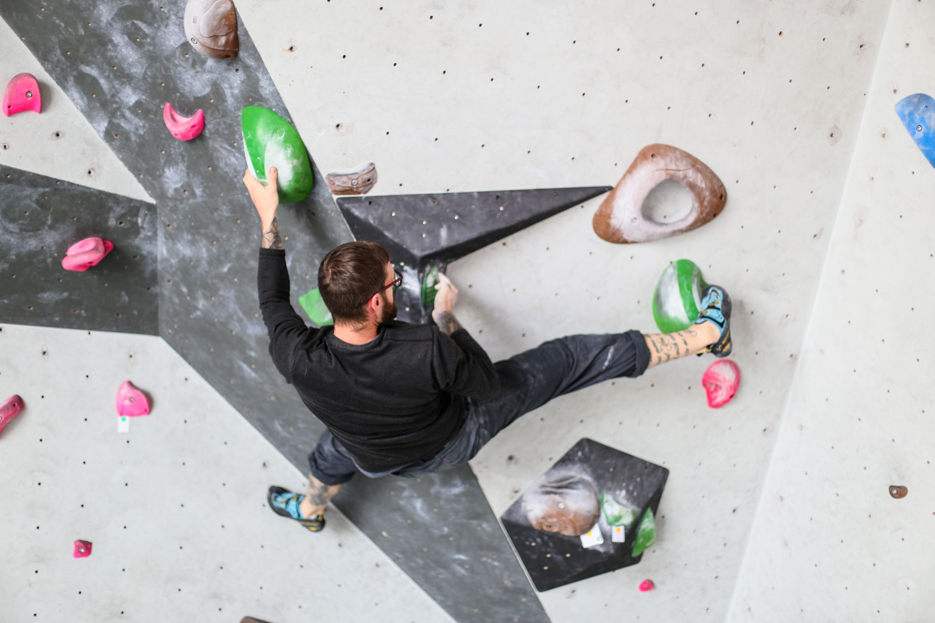 Mann klettert an einer Kletterwand